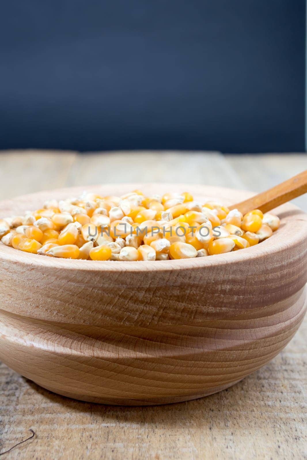 Corn seed in the wooden bowl with the wooden spoon