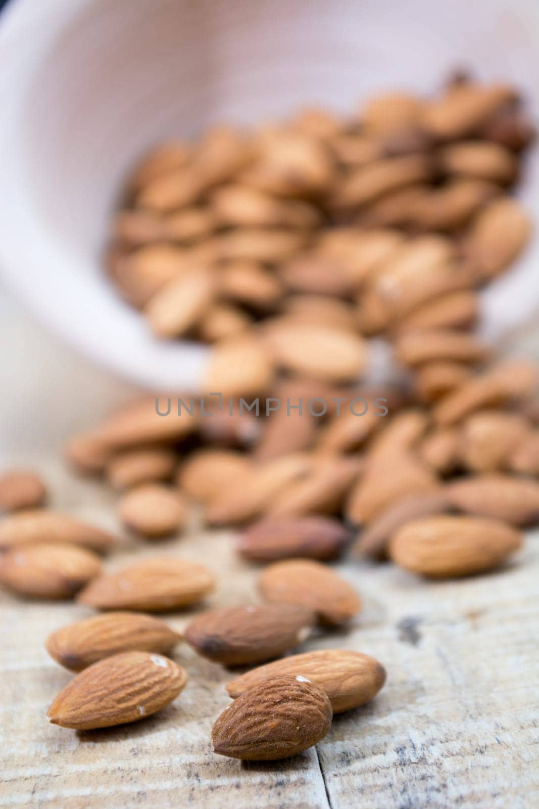 Spilled almonds out of the bowl on the table