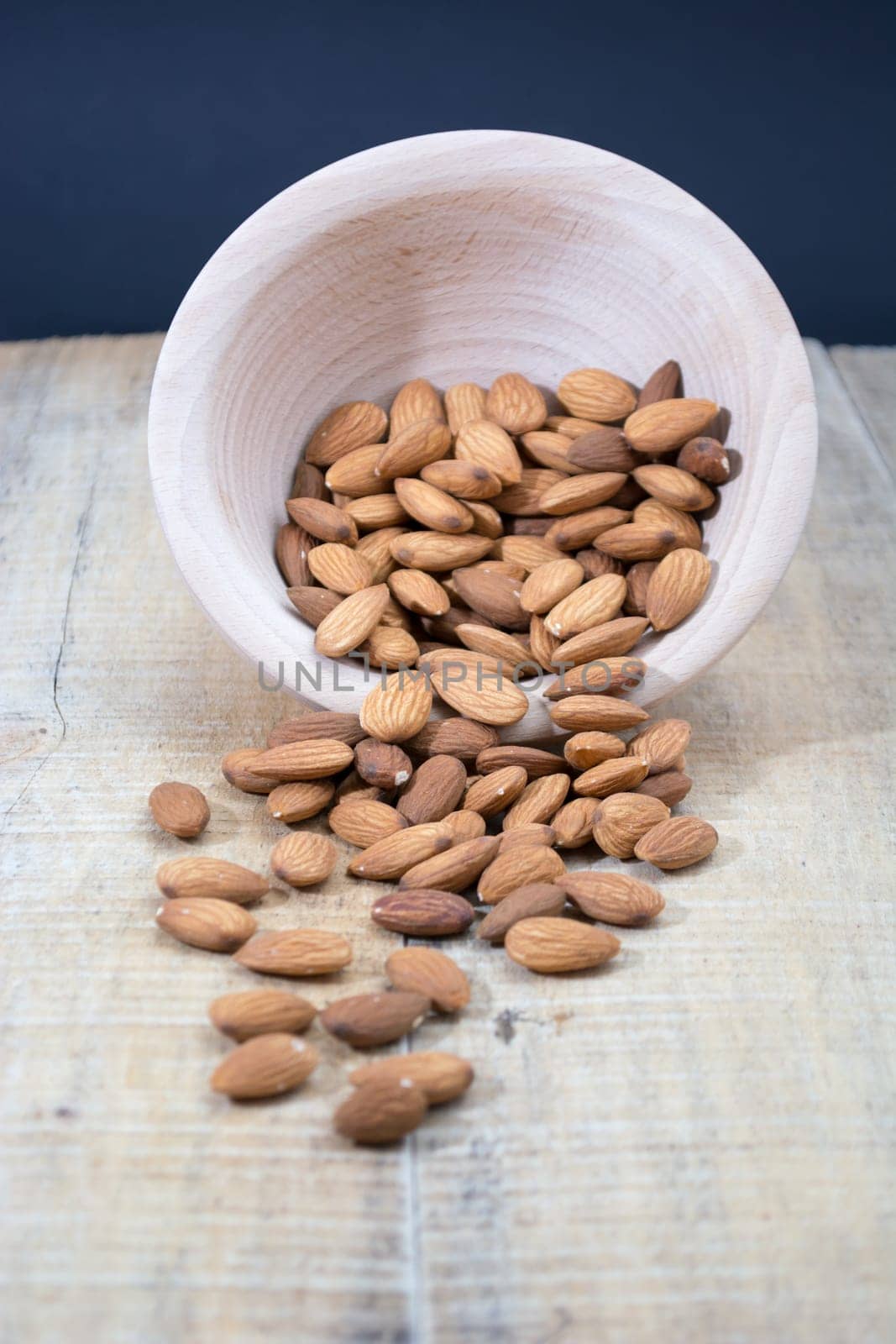 Spilled almonds out of the bowl on the table