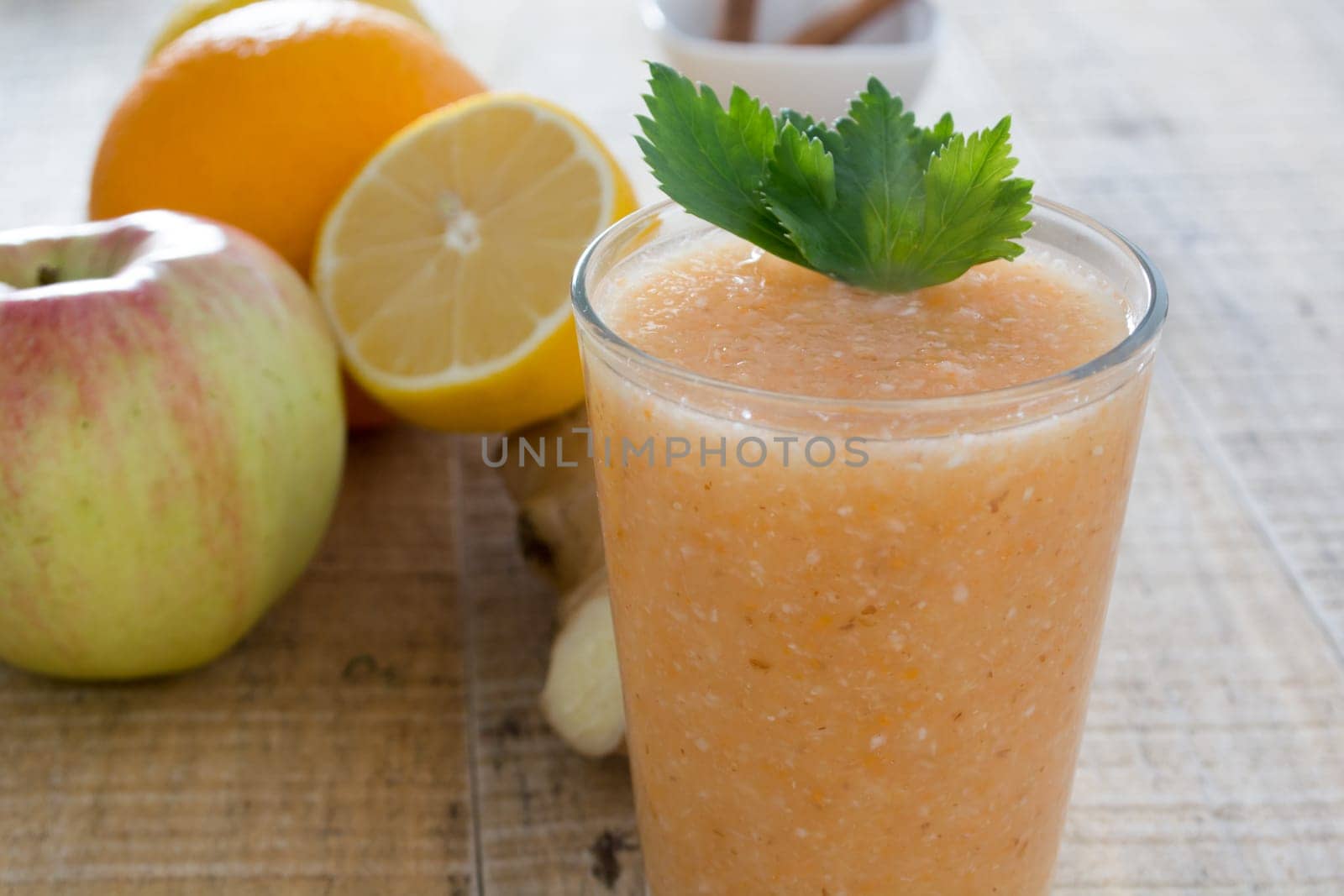 Fresh lemonade with ginger served on a table full with other fruits and cinnamon