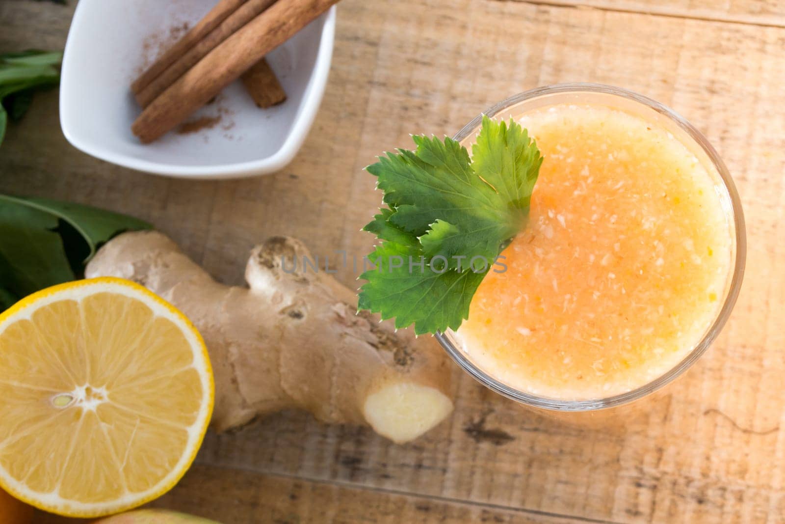 Fresh lemonade with ginger served on a table full with other fruits and cinnamon