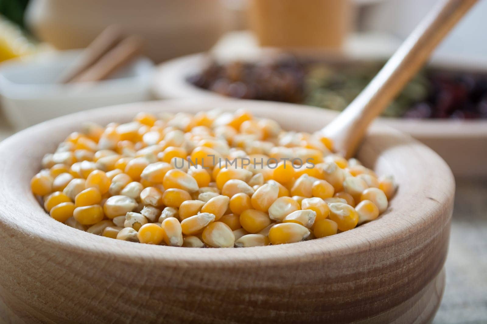 Corn seed in the wooden bowl with the wooden spoon