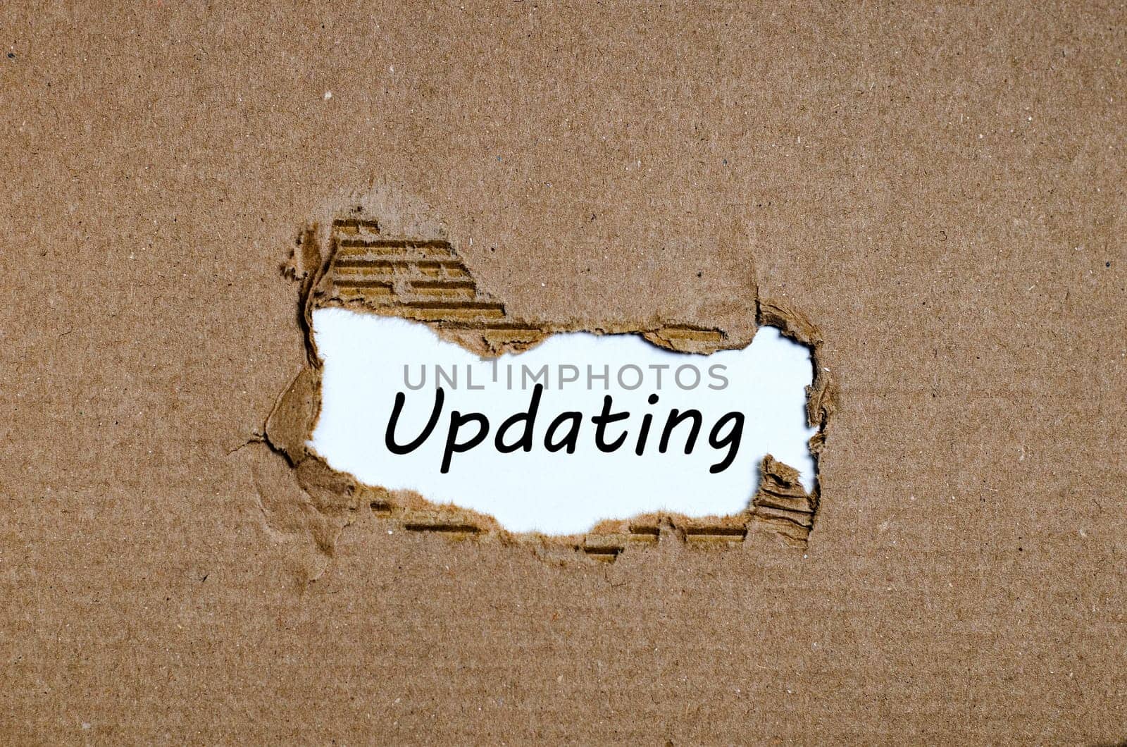 The word updating appearing behind torn paper