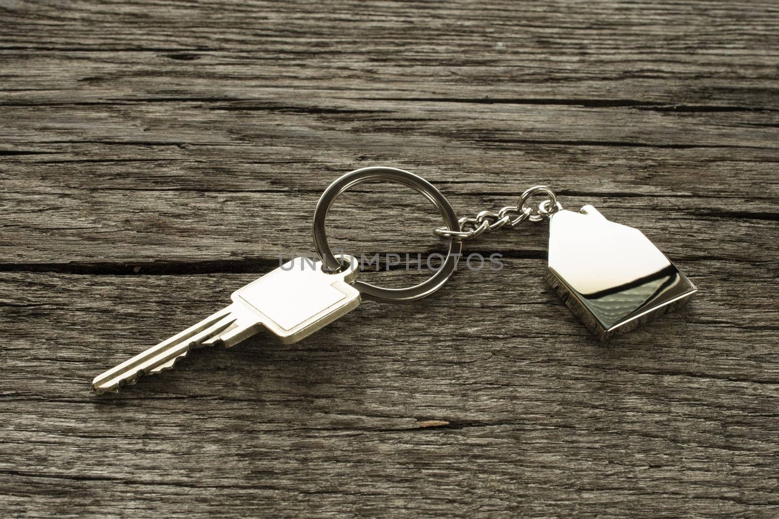 Key with keychain house on a wooden board