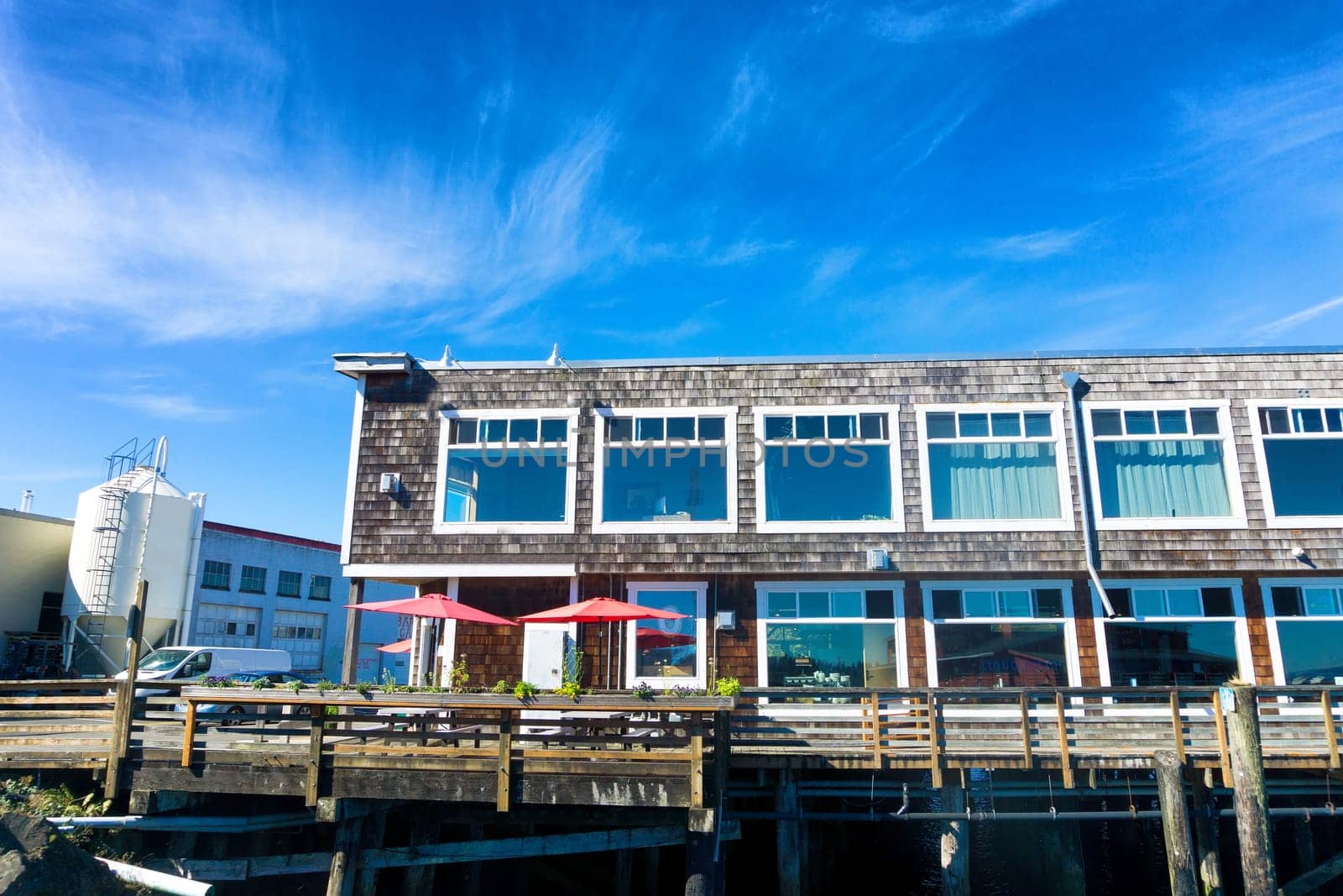 Red umbrellas add a spot of color to a building onthe waterfront in Astoria, Oregon