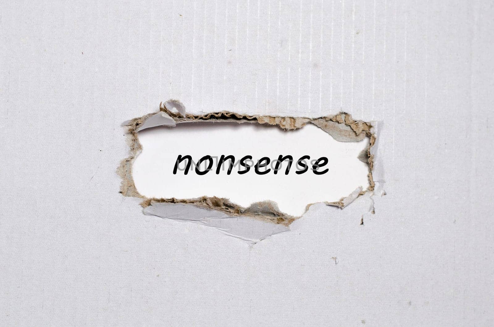 The word nonsense appearing behind torn paper