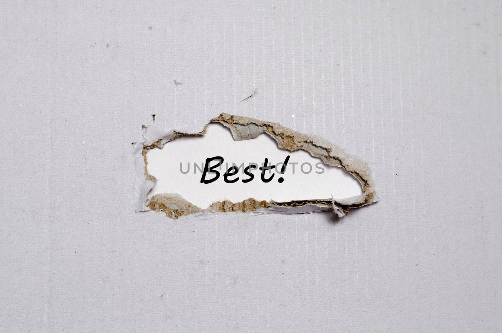 The word best appearing behind torn paper