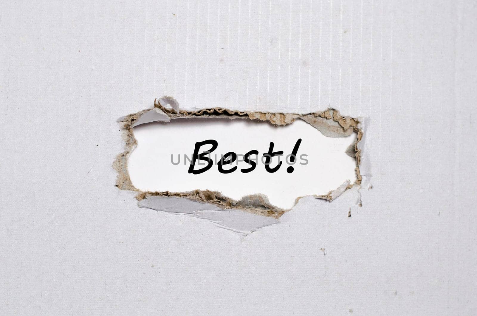 The word best appearing behind torn paper