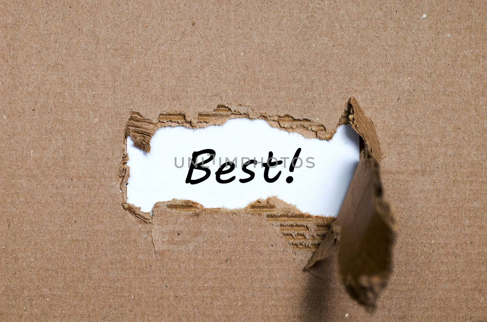 The word best appearing behind torn paper