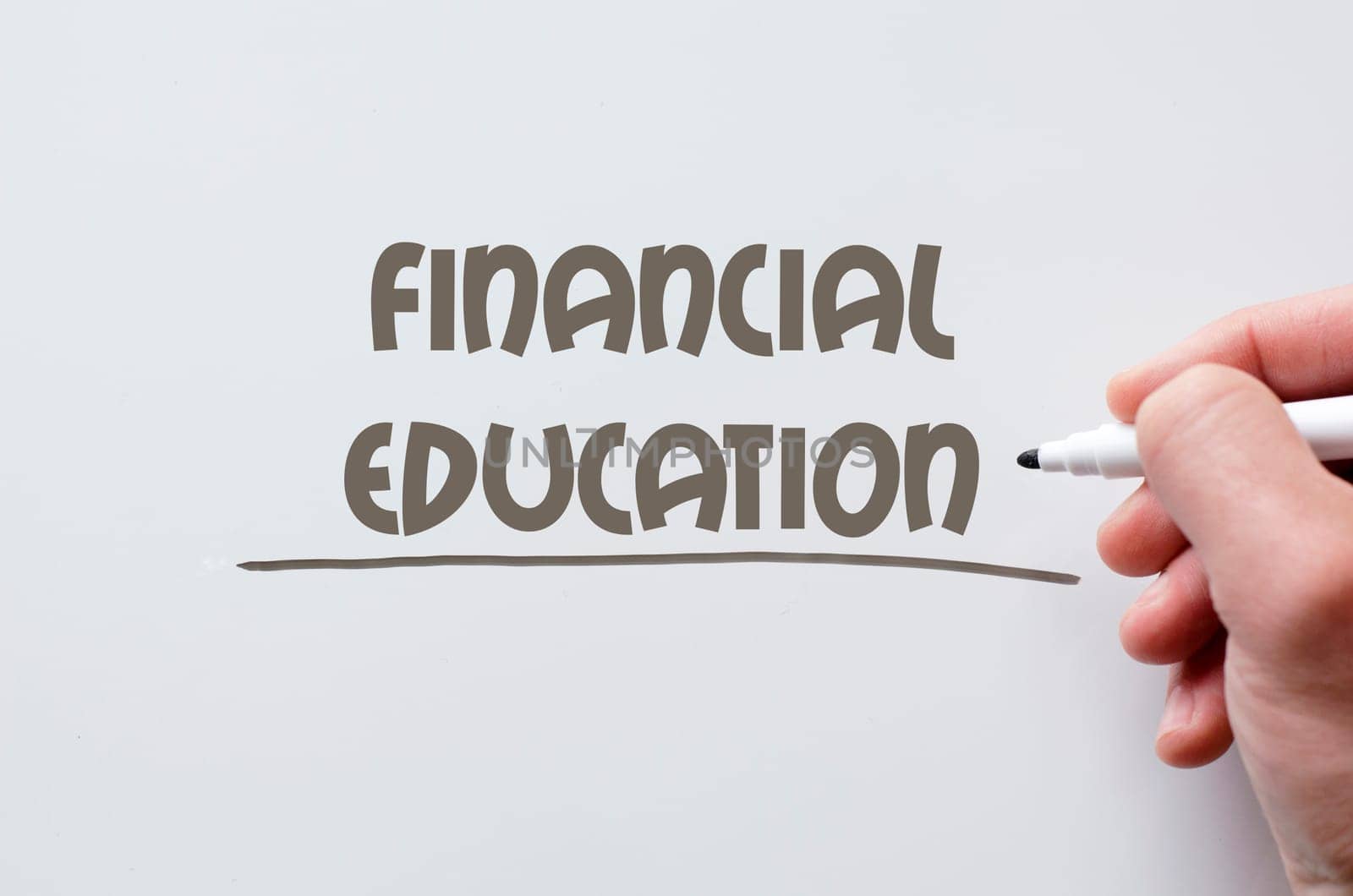 Human hand writing financial education on whiteboard
