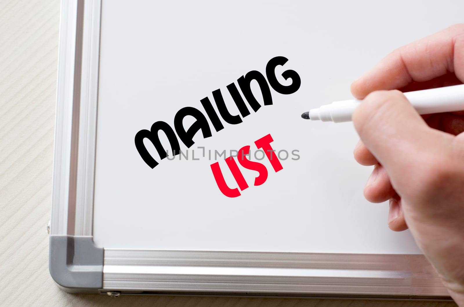 Human hand writing mailing list on whiteboard