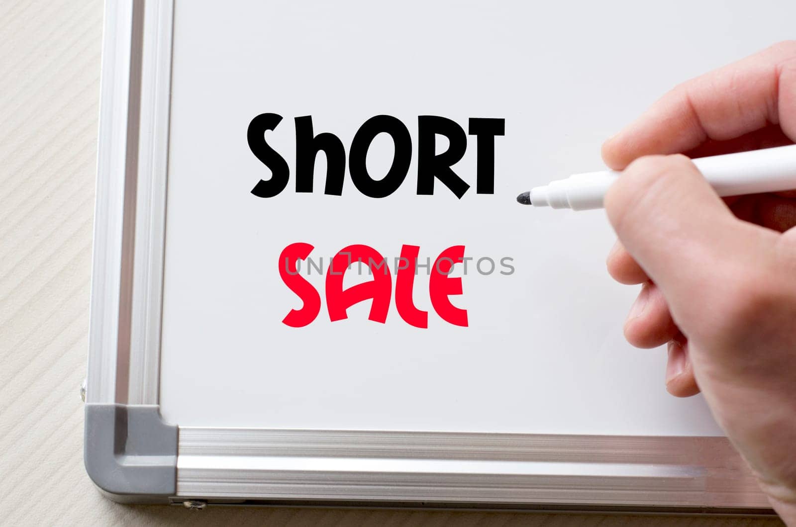 Human hand writing short sale on whiteboard