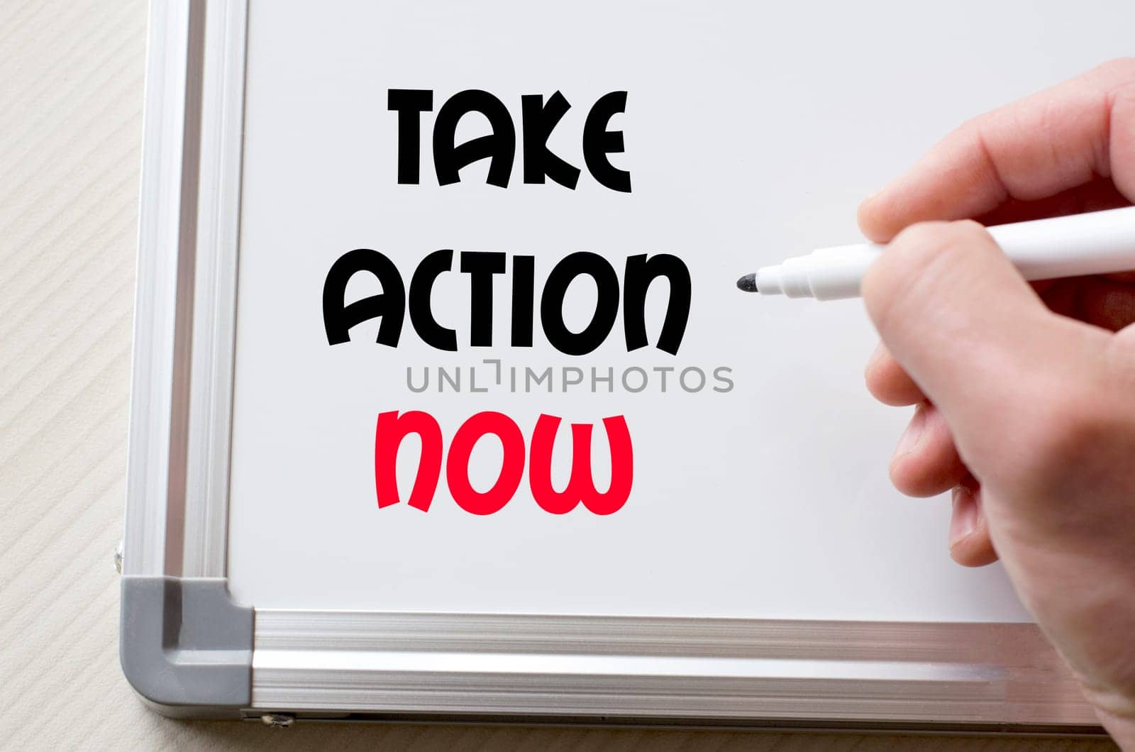 Human hand writing take action now on whiteboard