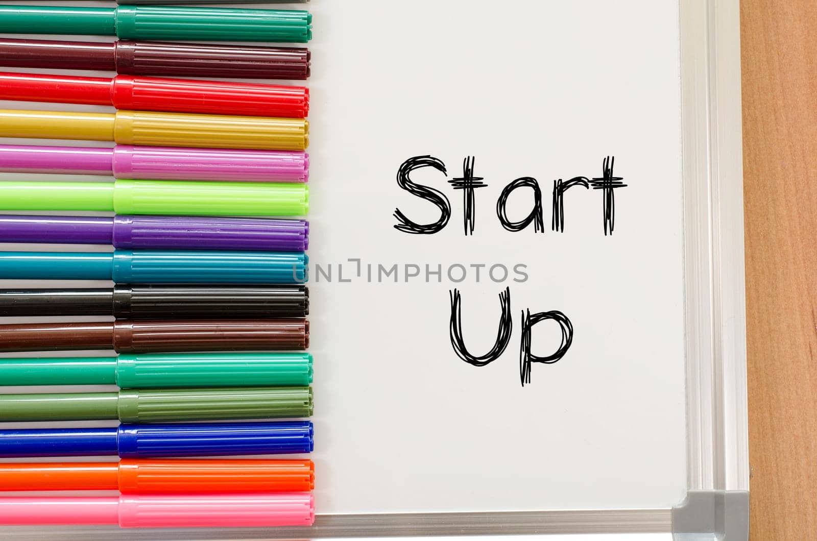 Felt-tip pen and whiteboard on a wooden background