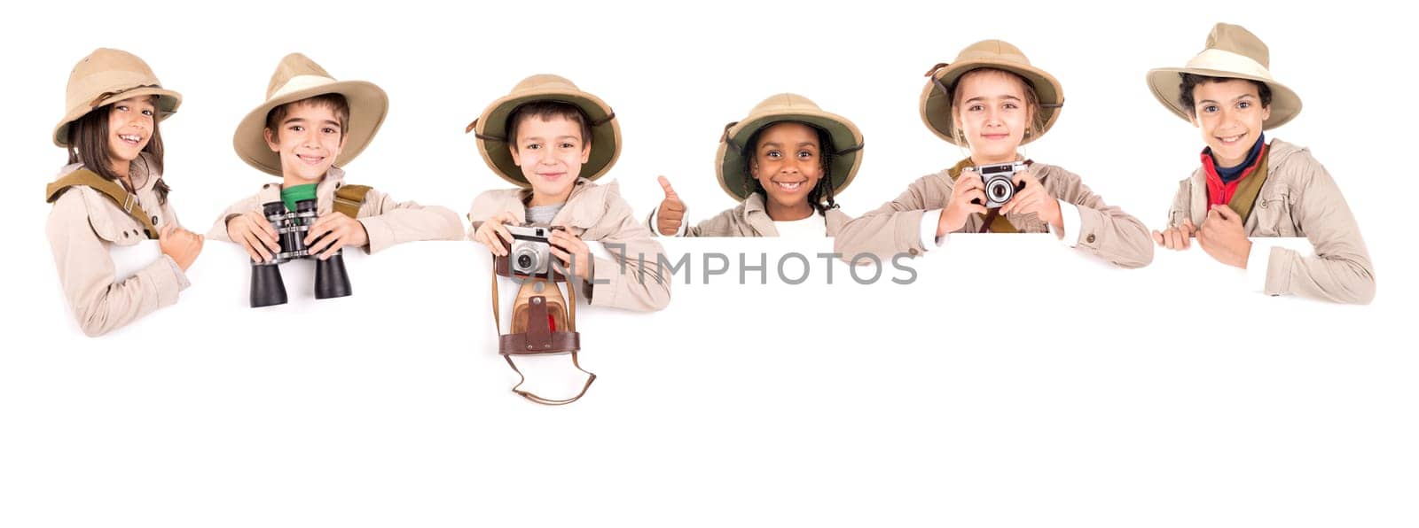 Children's group with safari clothes and gear over a white board