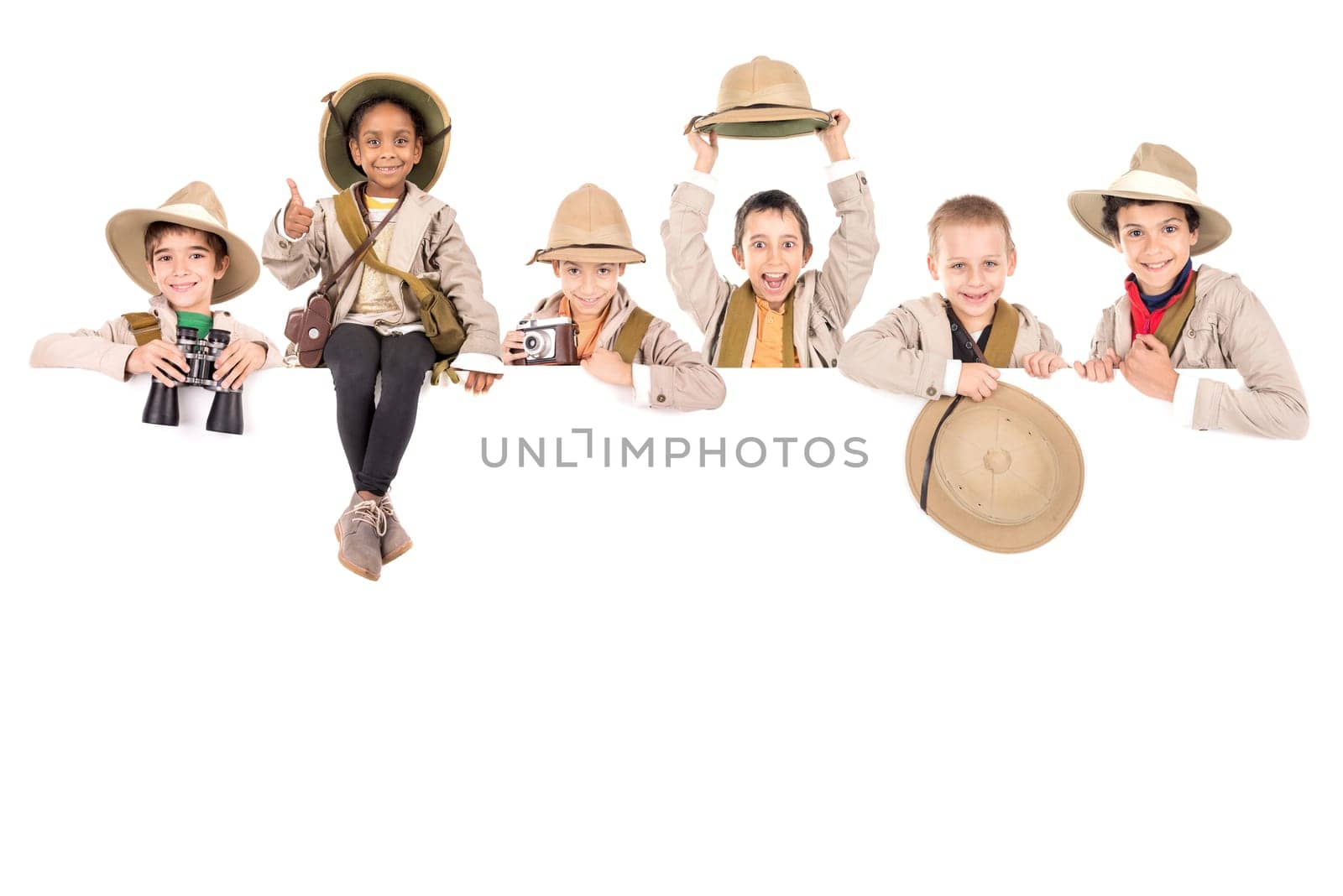 Children's group with safari clothes and gear over a white board