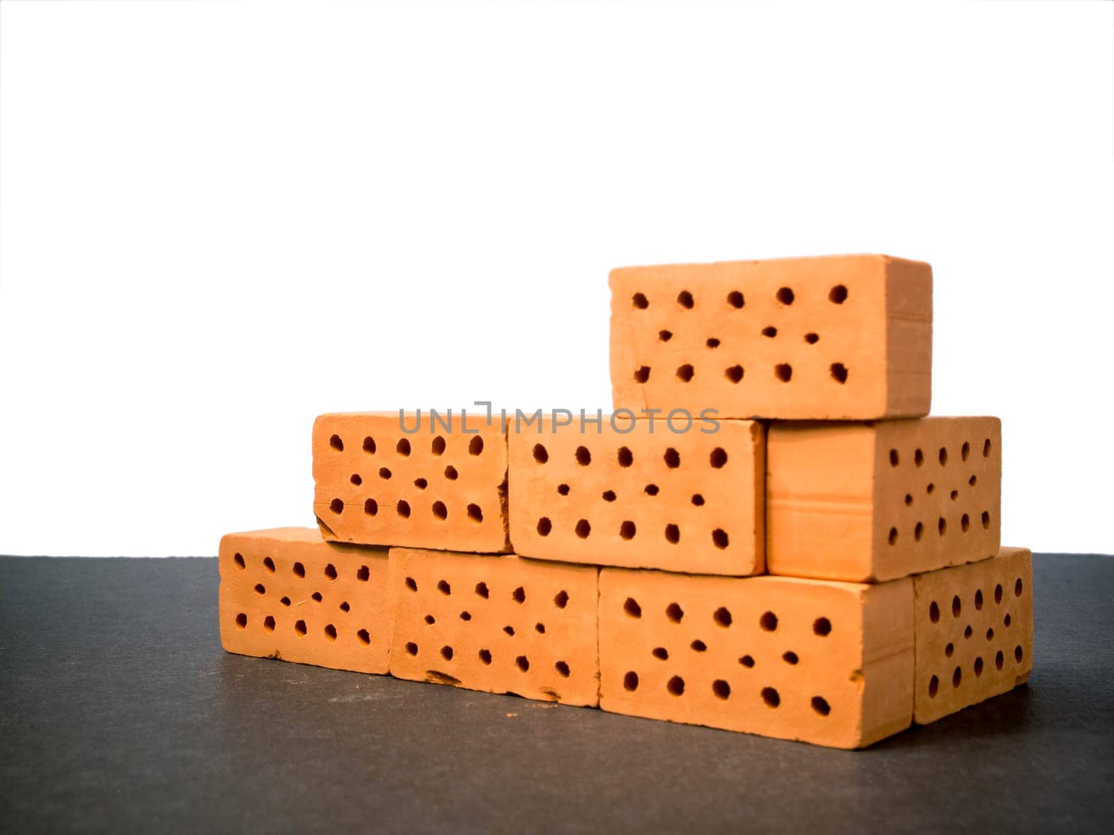 indicated masonry of toy bricks on slate substrate against a white background