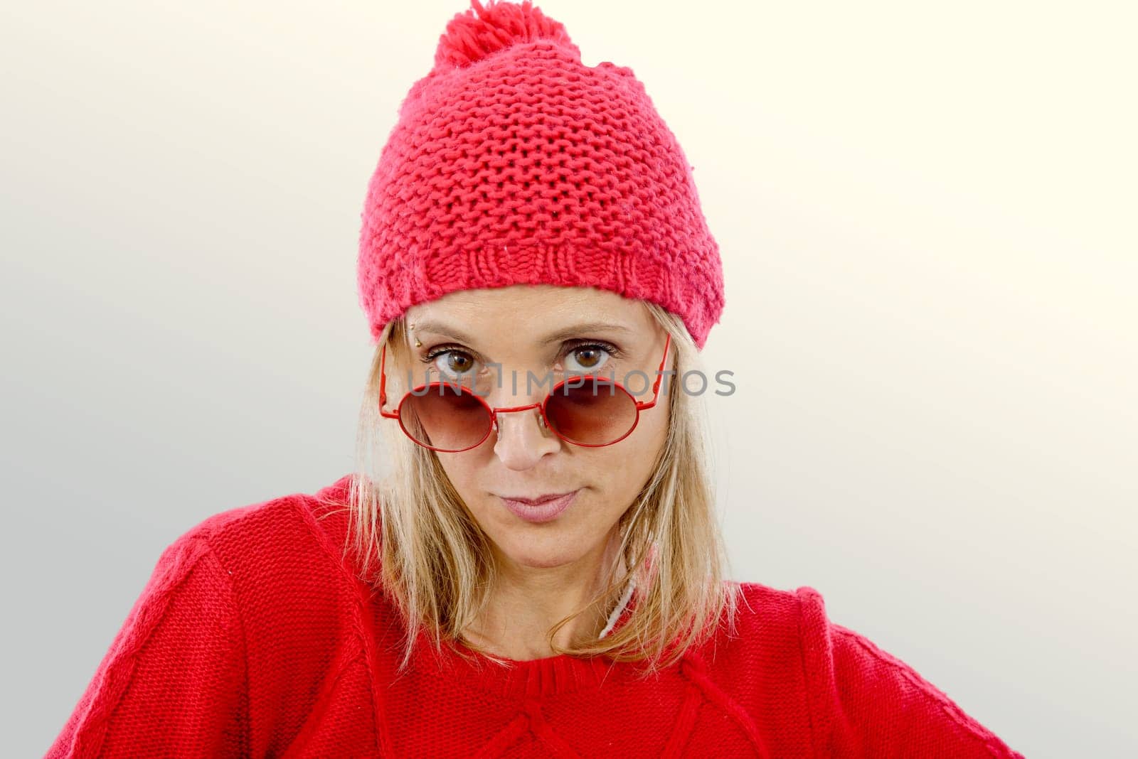 fashion blonde woman with red  sweater and winter hat