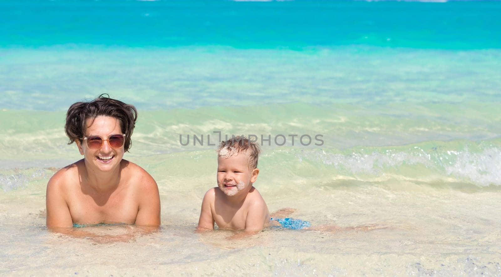 Mother and son relaxing in the sea. Mauritius. Panorama