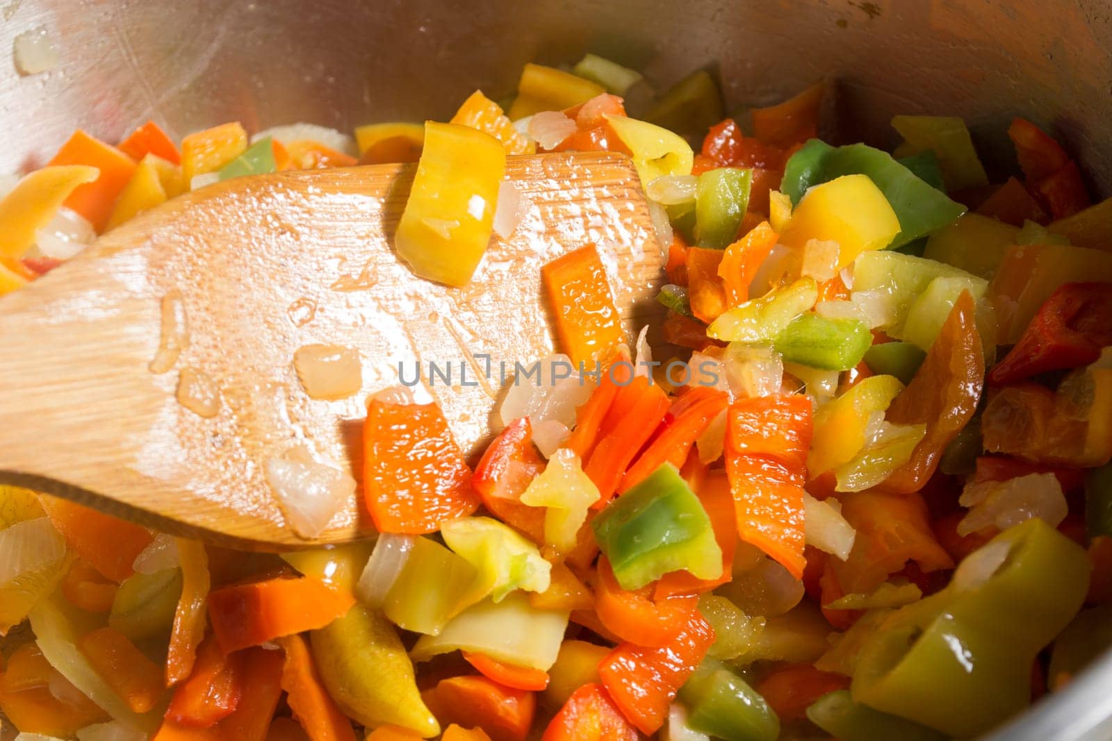 Cooking stew with fresh vegetables in a pot. Mixing it with mixing spoon