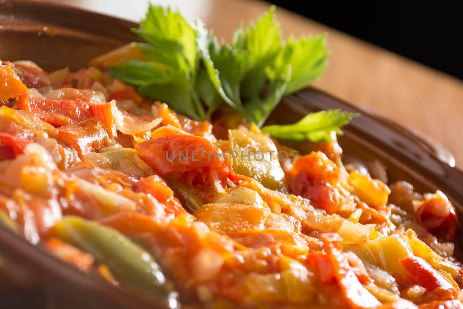 Closeup of delicious stew with mixed vegetables, arranged with green leaves