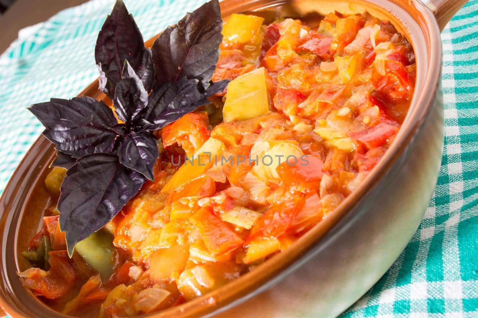 Closeup of delicious stew with mixed vegetables, arranged with green and purple leaves