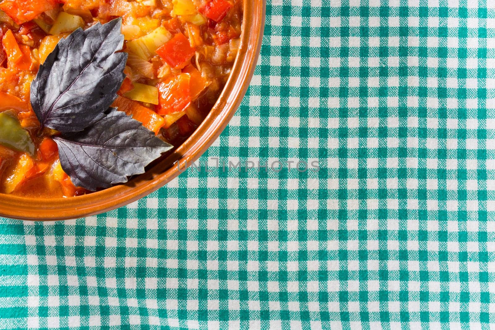 Closeup of delicious stew with mixed vegetables, arranged with green and purple leaves