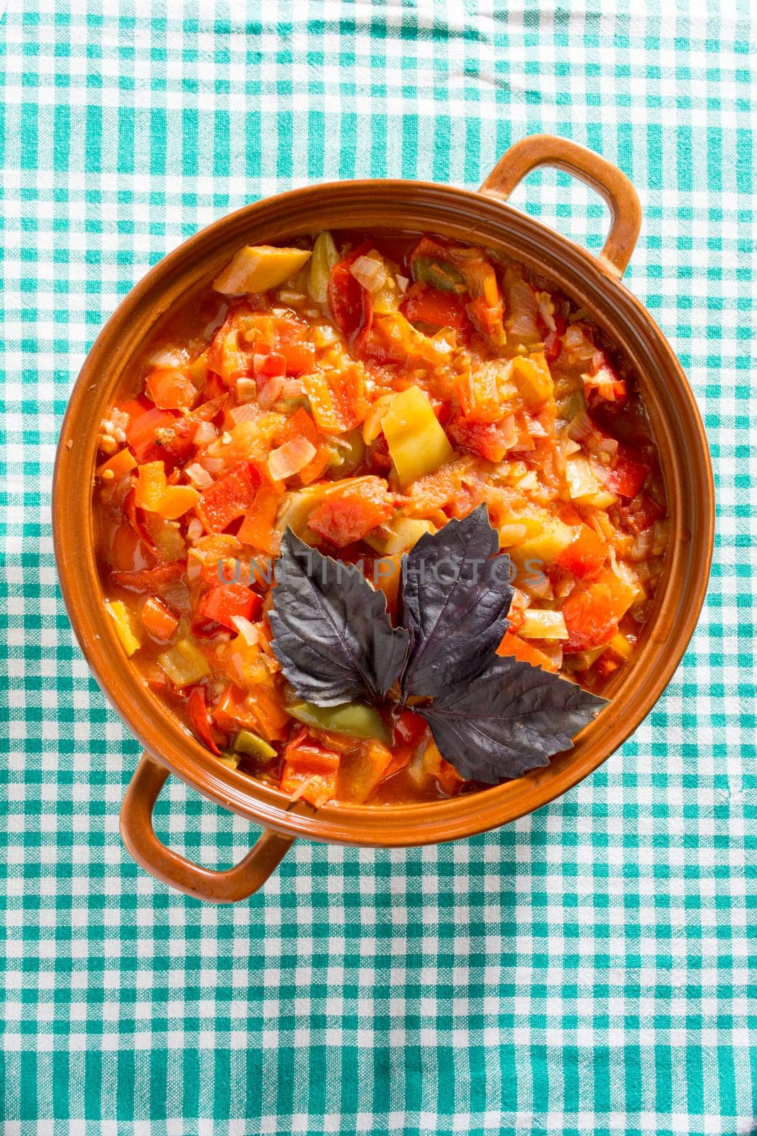 Closeup of delicious stew with mixed vegetables, arranged with green and purple leaves