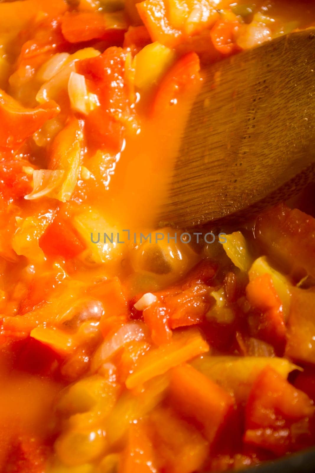 Cooking stew with fresh vegetables in a pot. Mixing it with mixing spoon