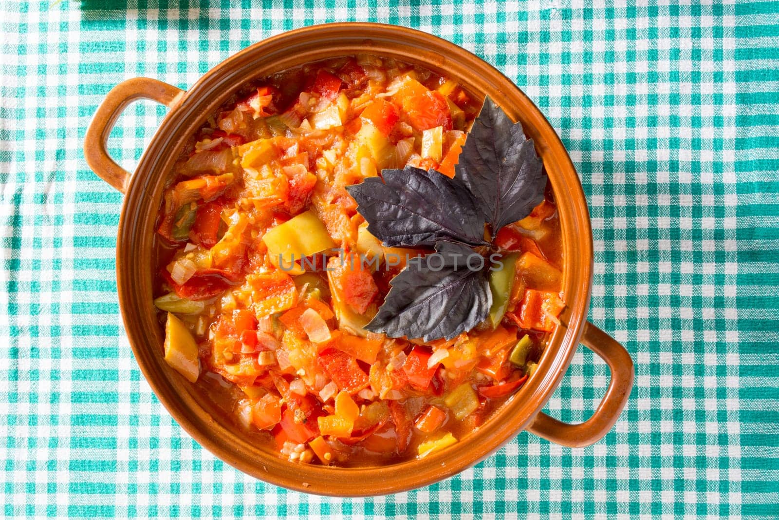 Closeup of delicious stew with mixed vegetables, arranged with green and purple leaves