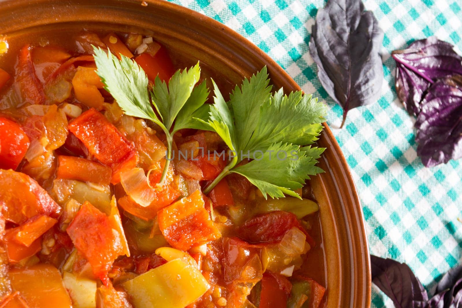 Closeup of delicious stew with mixed vegetables, arranged with green and purple leaves