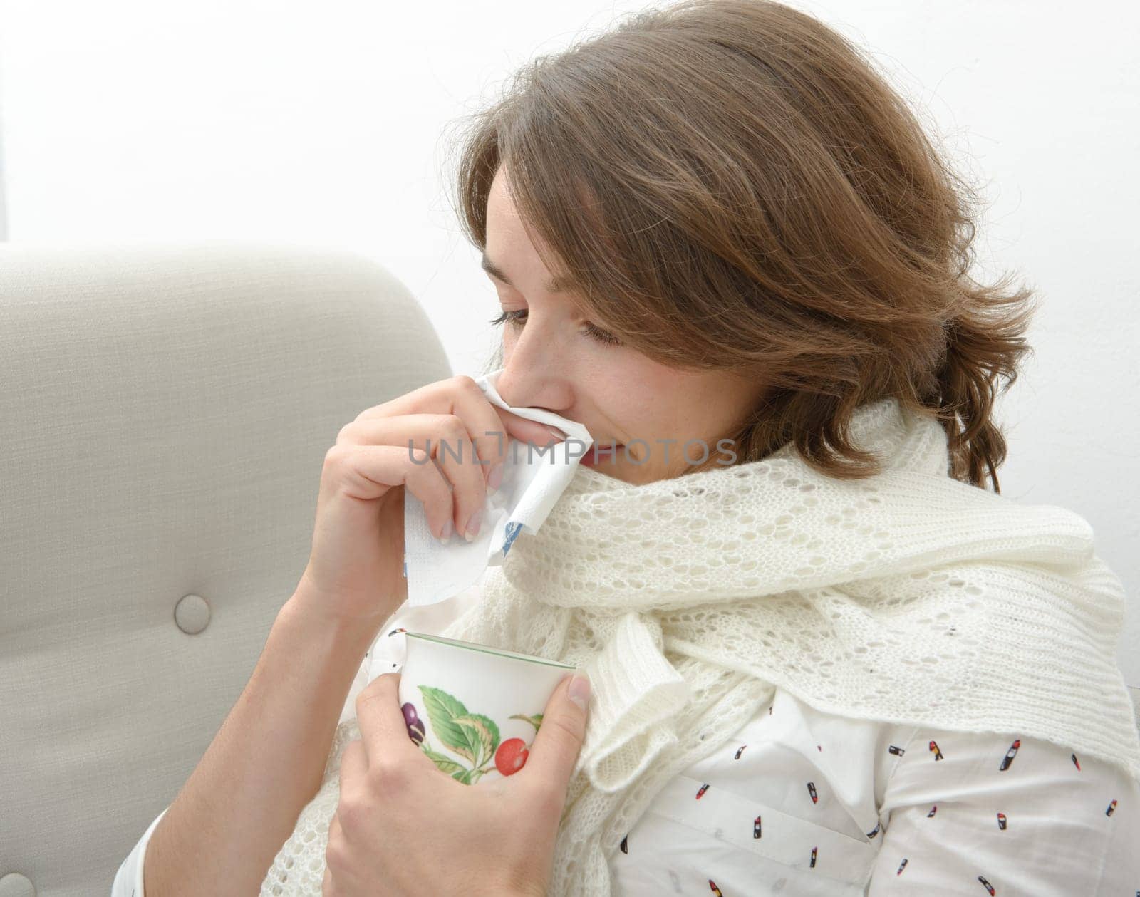 young woman is suffering from a cold and drink tea