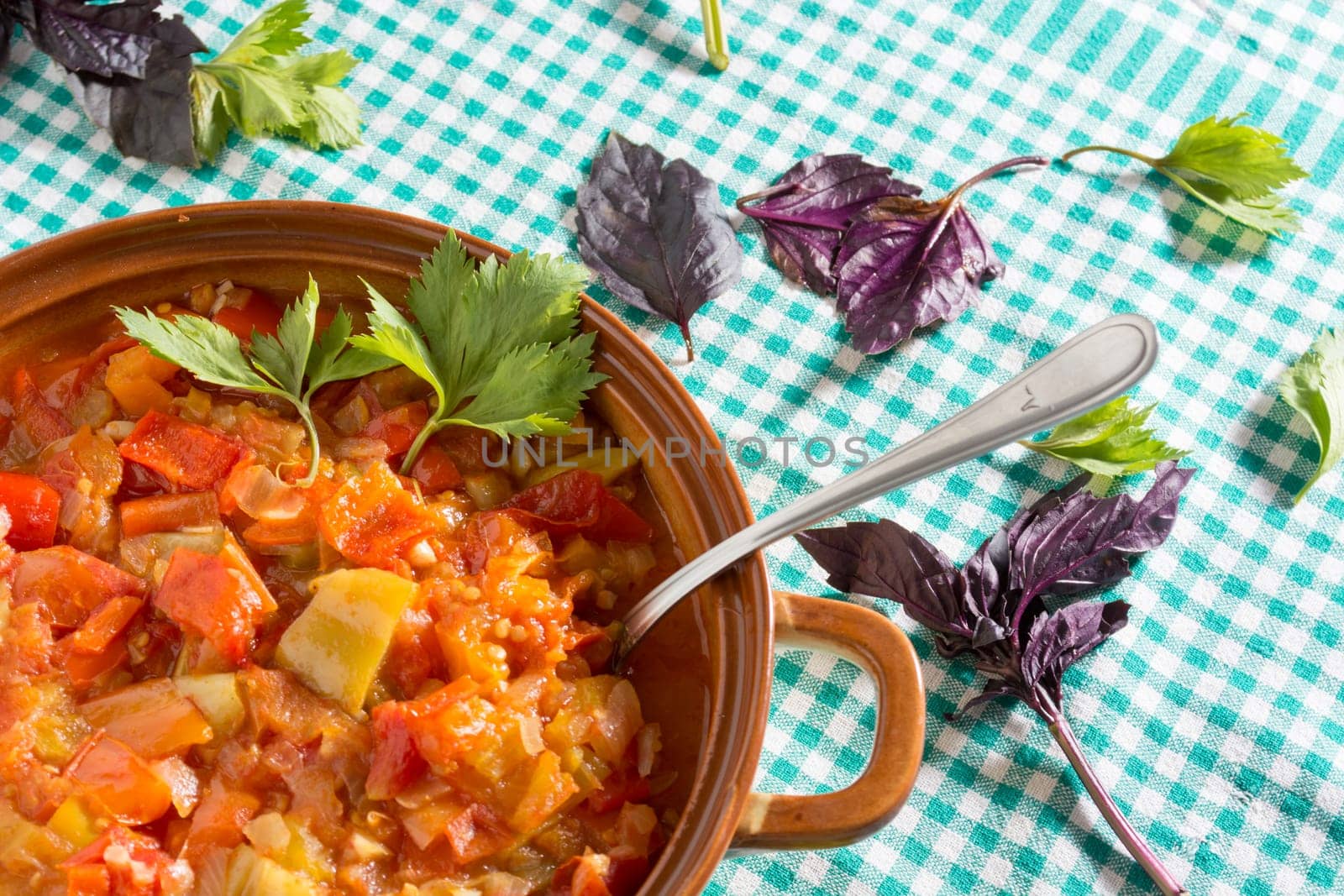 Closeup of delicious stew with mixed vegetables, arranged with green and purple leaves