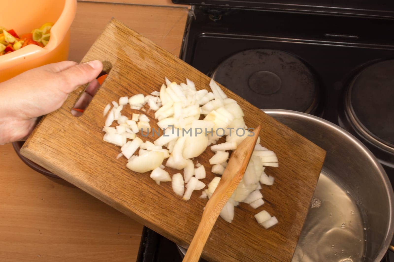 Putting chopped onion in frying pan