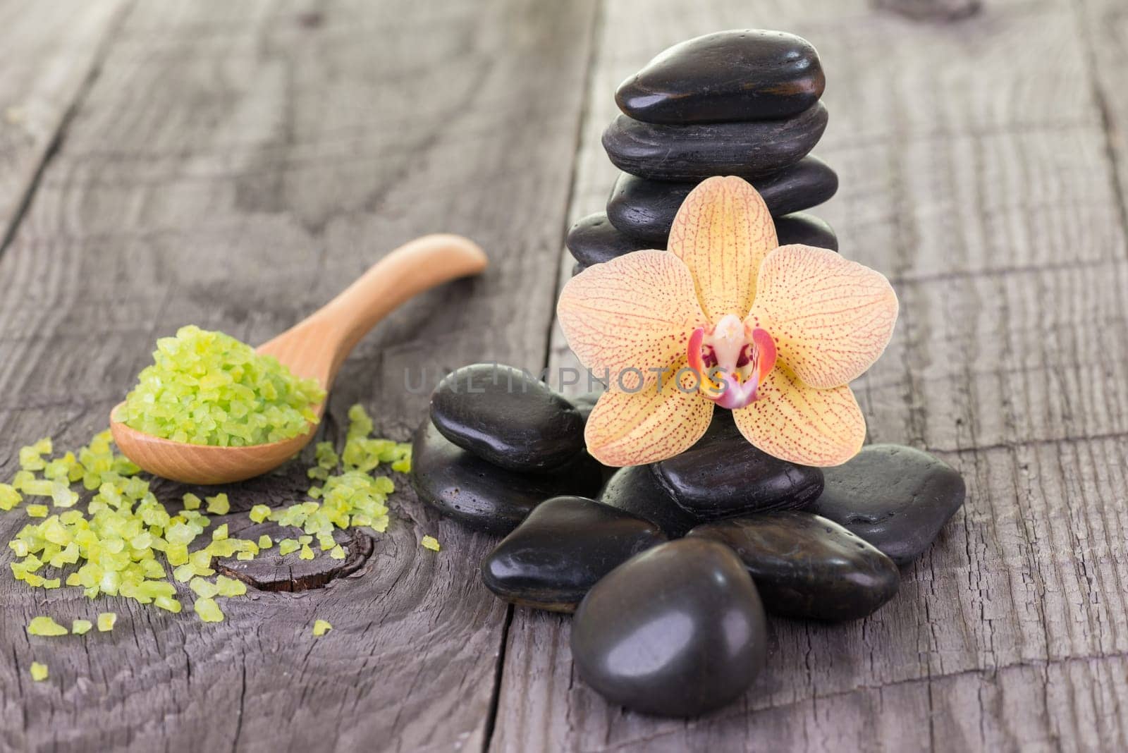 Spa with bath salt and hot stones on wooden background
