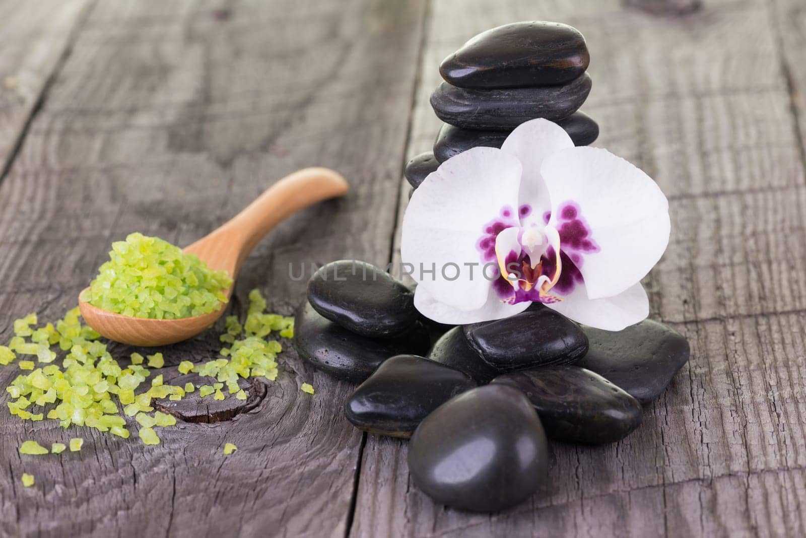 Spa with bath salt and hot stones on wooden background