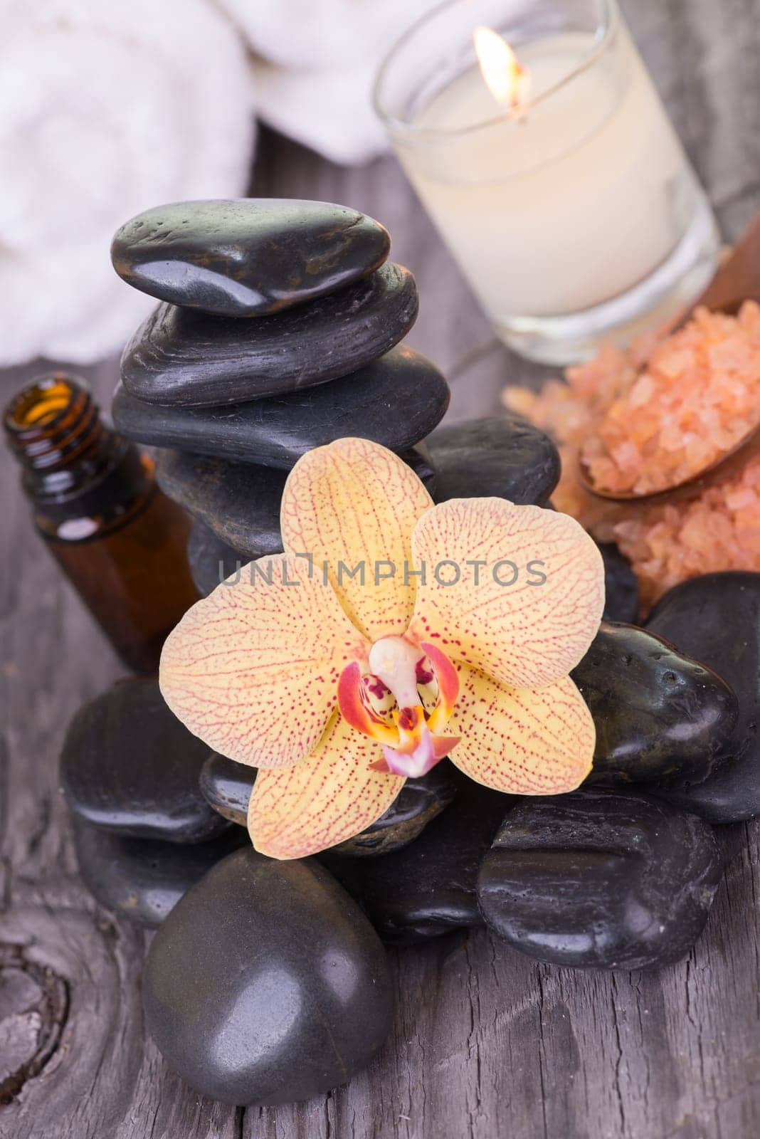 Spa with hot stones, bath salt, essential oil and towels close up