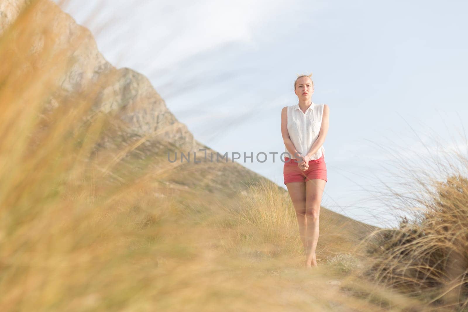 Woman, arms crossed, feeling chilled, enjoying last autumn sun, an beautiful Balos beach. Concept of vacations, freedom, happiness, enjoyment and well being.