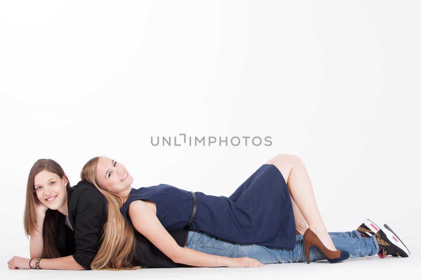 Two happy young girls on a white background in the studio
