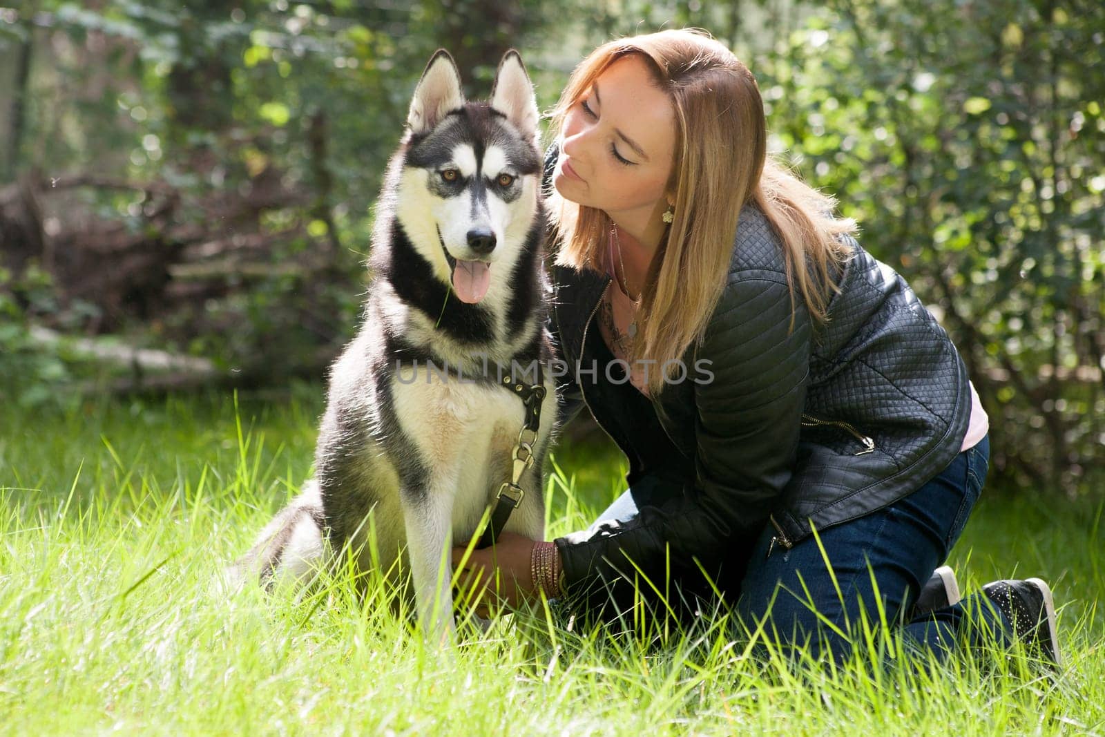 Young woman and her husky in the forest