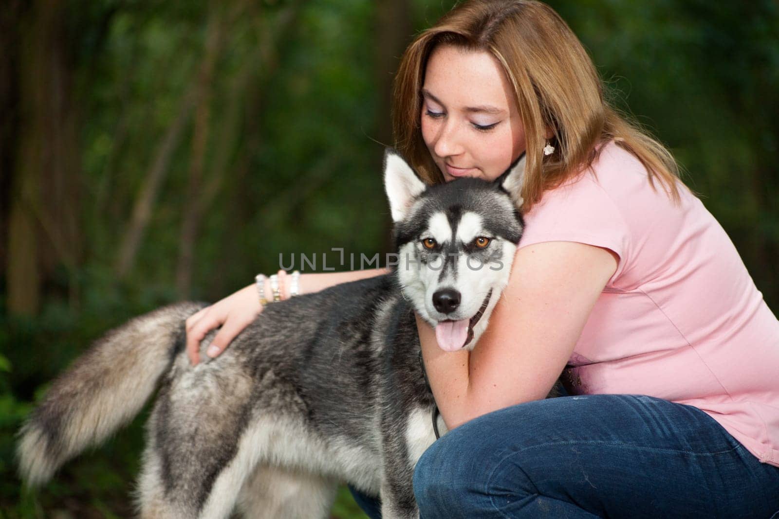 Young woman and her husky in the forest