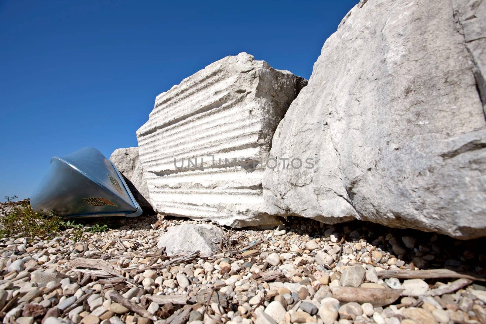Lighthouse on Lake Huron rocks and blue canoe