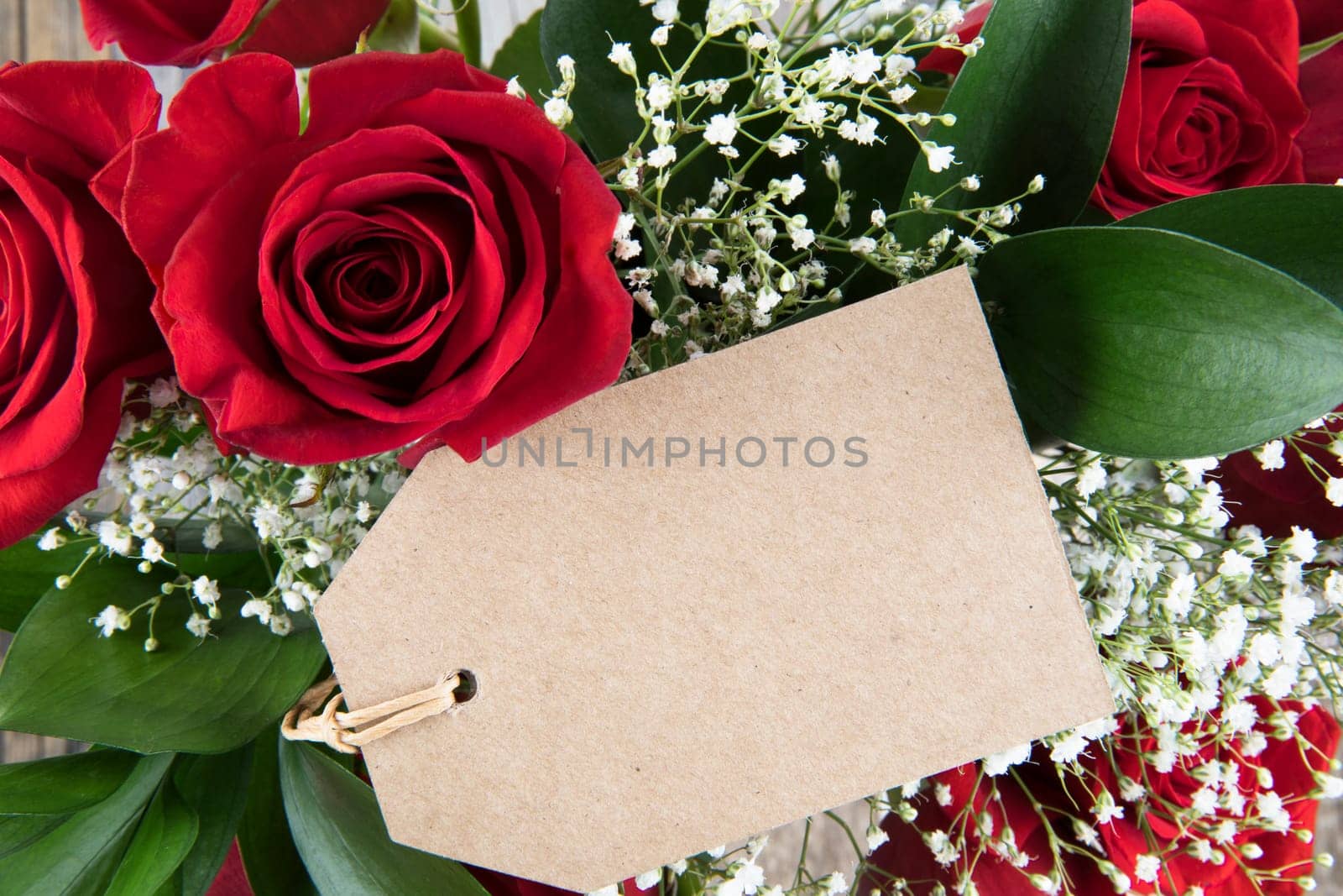 Red roses and baby's breath and gift tag with copy space