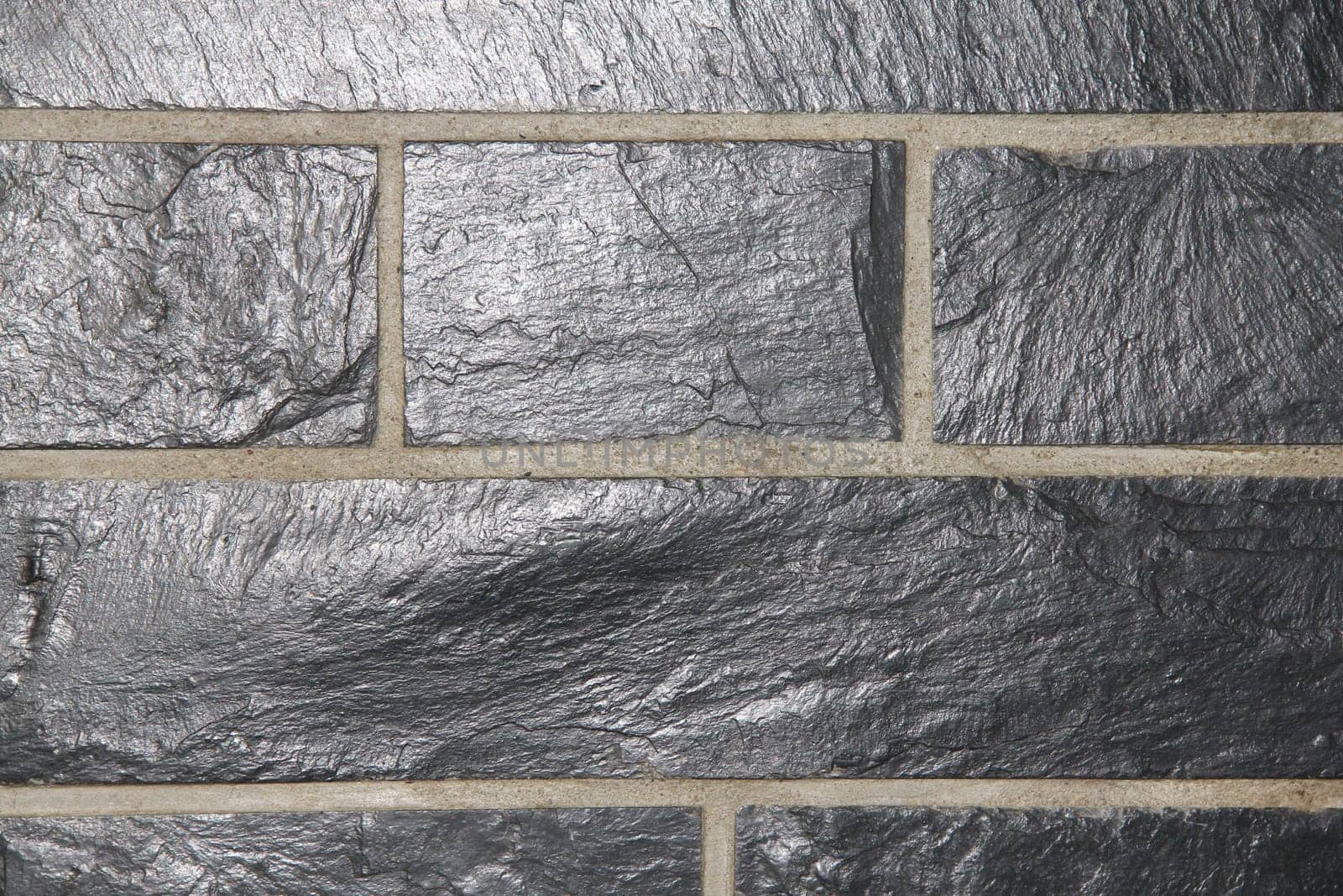 A wall cladding made of grey slate slabs.
