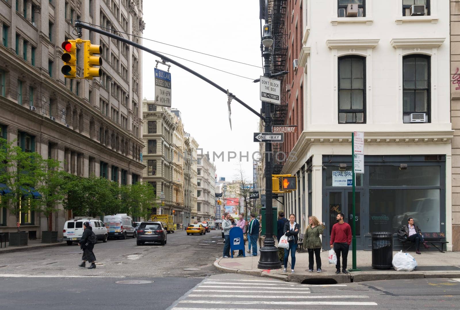 NEW YORK - MAY 2, 2016: Ordinary street scene in Manhattan with unknown people in front of a pedestrian crossing