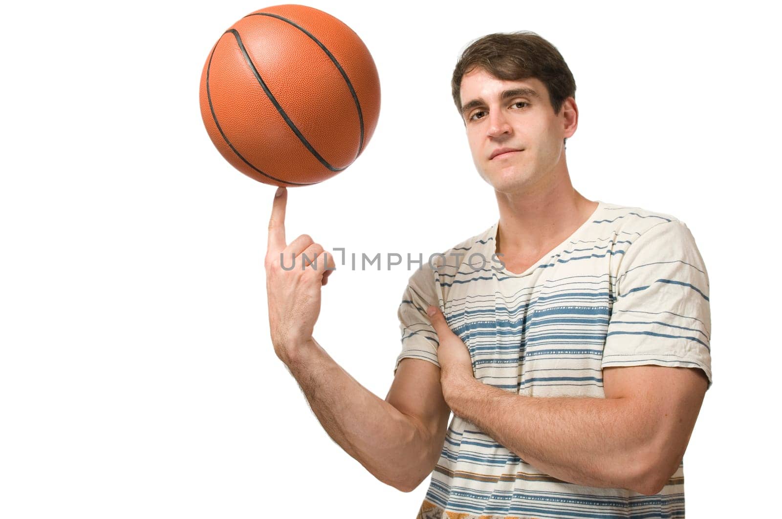 Lateral upper body view of a young man in a t-Schirt balancing a basketball on his index finger against a white background.