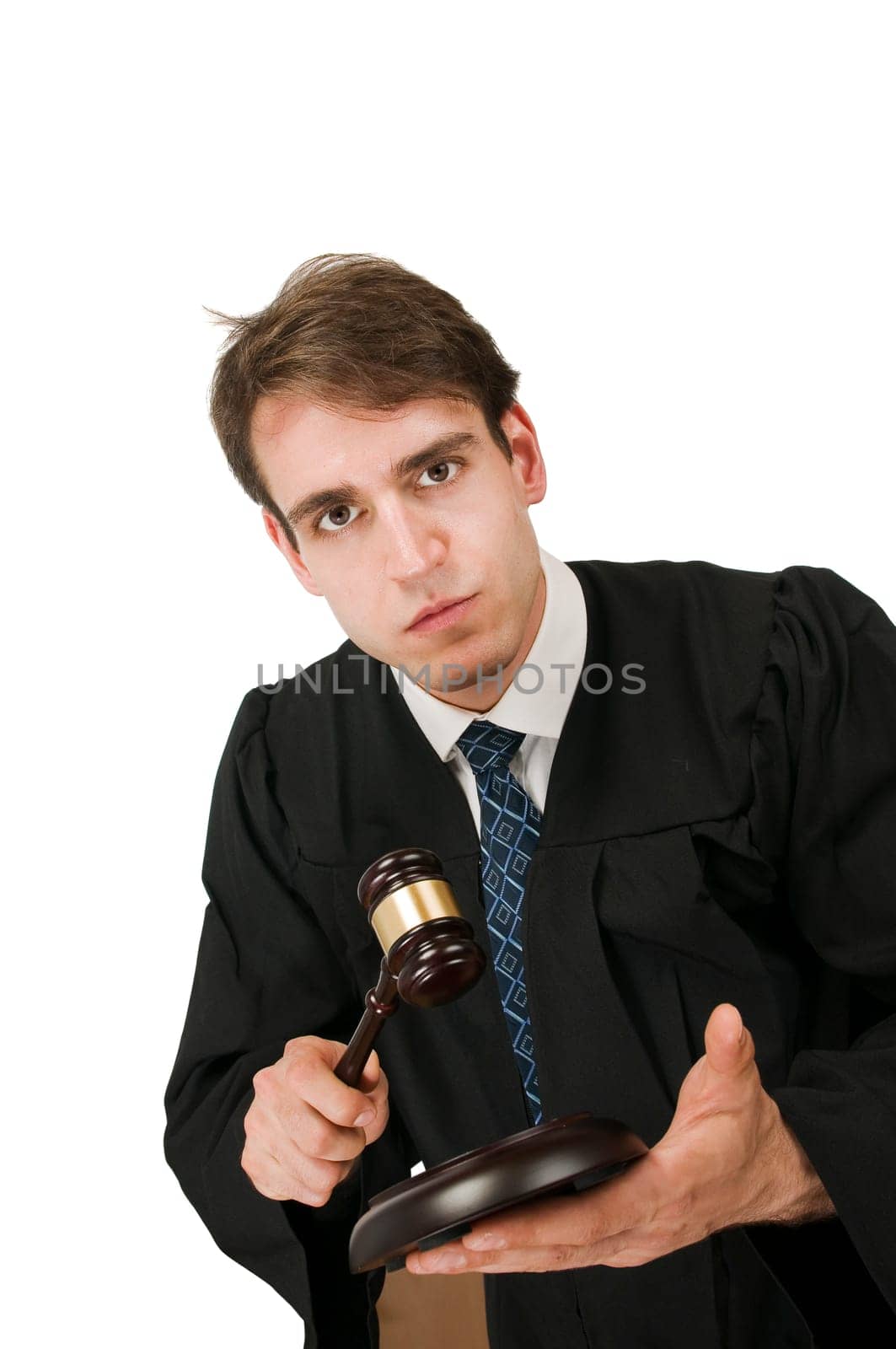 Oblique upper body view of a young man against a white background in a black robe with a judge's hammer and first glance into the camera.