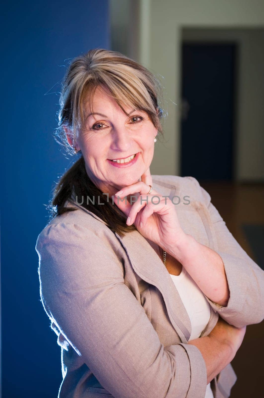 Side upper body portrait of a middle-aged woman in a blue vesthalle.