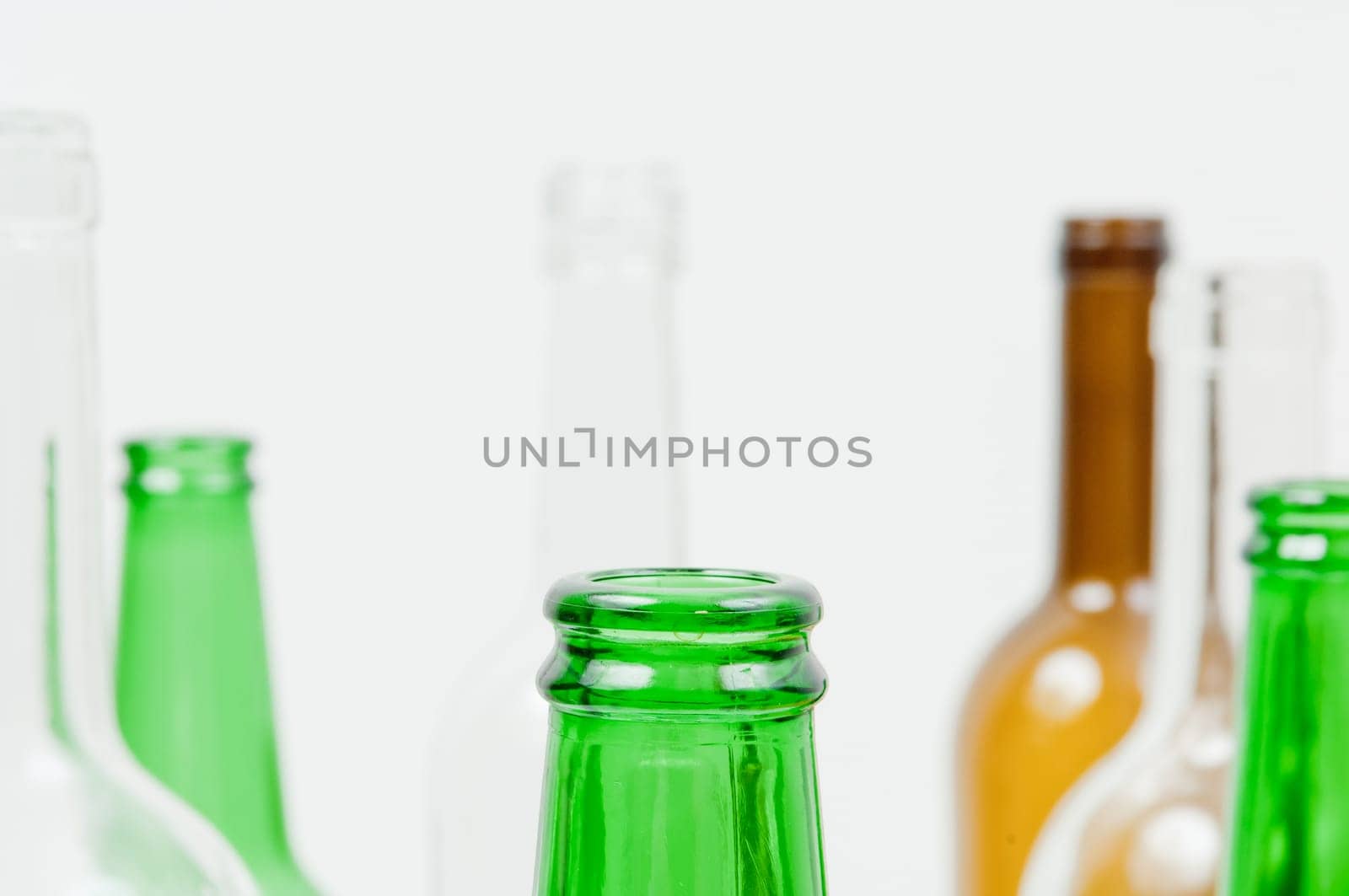 Empty glass bottles of mixed colors including green, clear white, brown