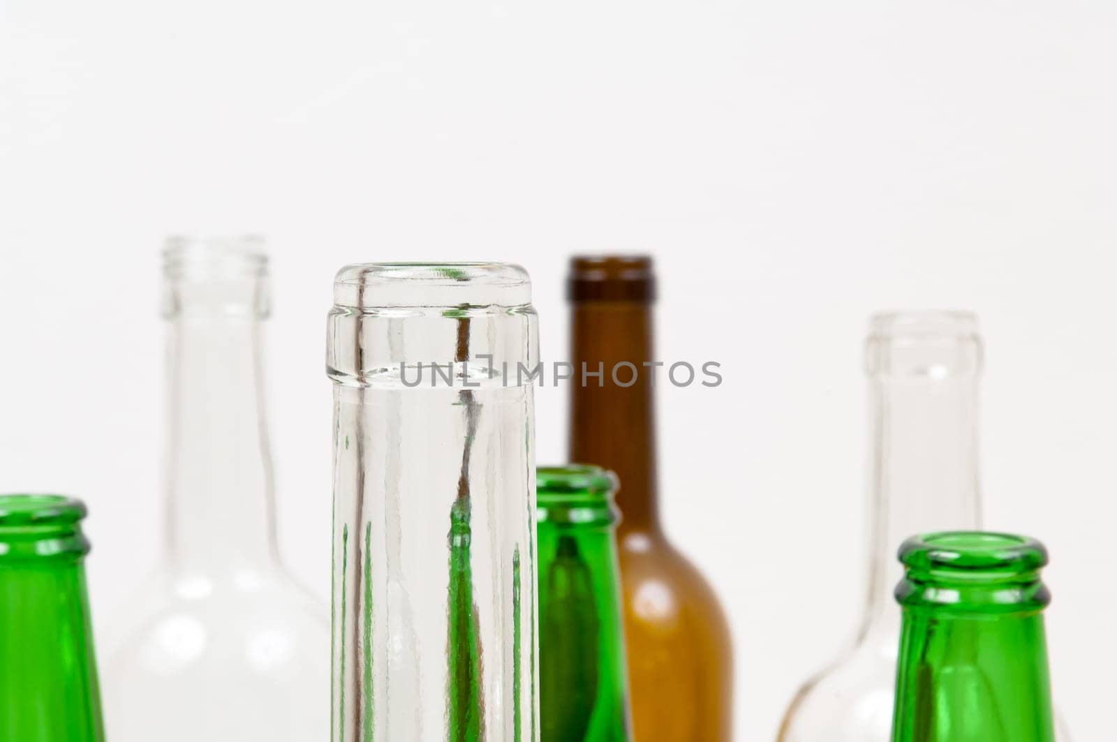 Empty glass bottles of mixed colors including green, clear white, brown